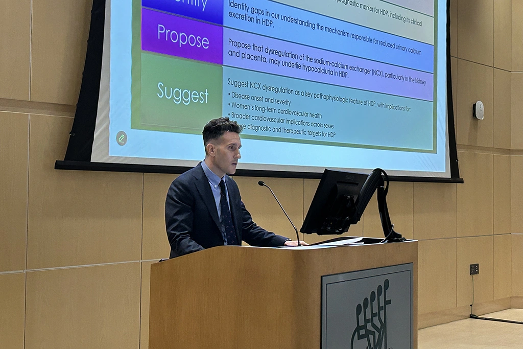 Man showcasing research at a podium on stage