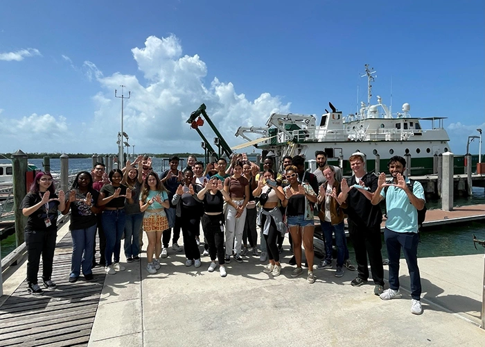 A group of UM students pose for ap hoto in front of a dock in Key Biscayne