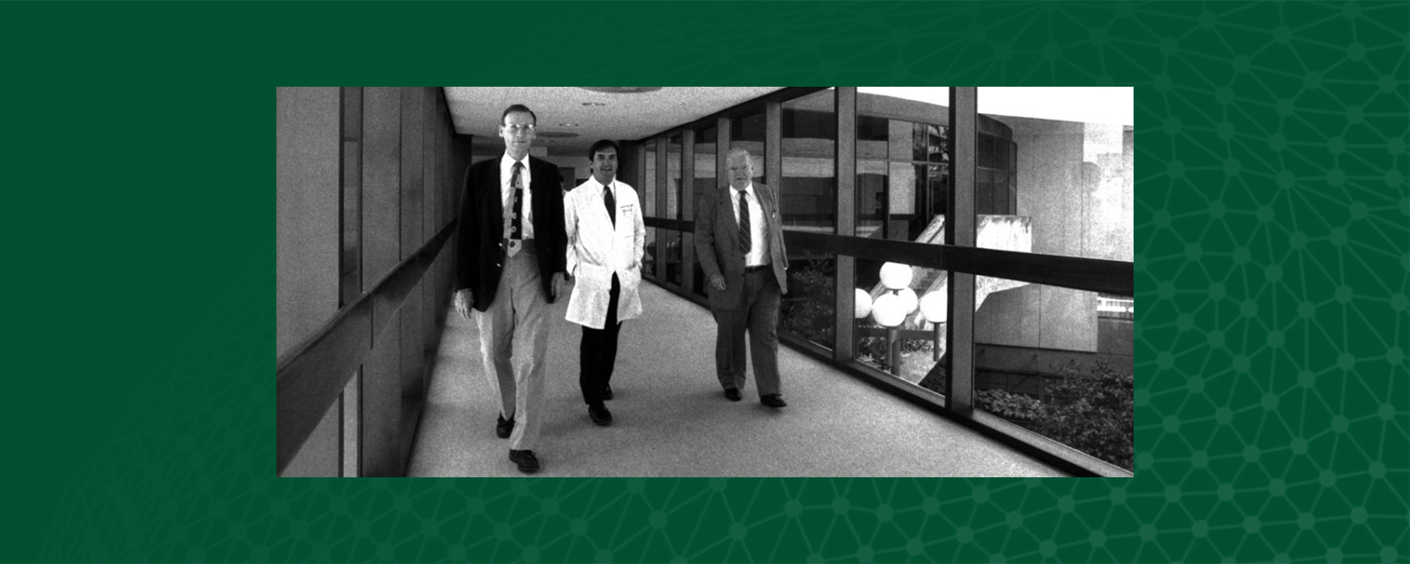 Black and white photo of men walking through a hallway