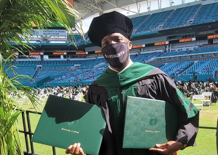 graduate takes a photo with dual degrees