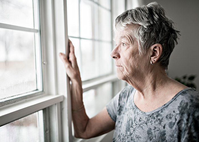 older woman looking out of a window