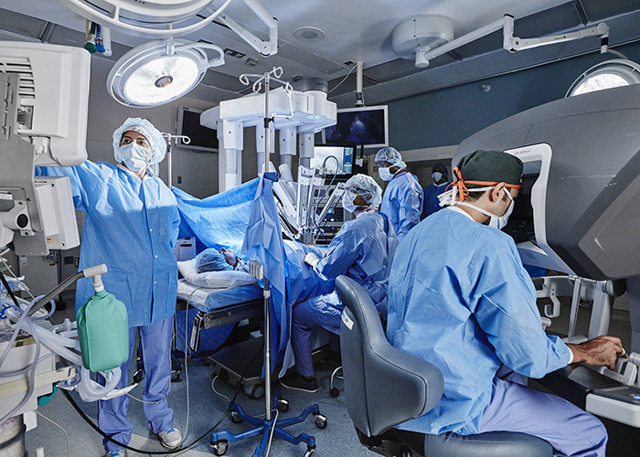 Surgeons performing a procedure using robotic assistance