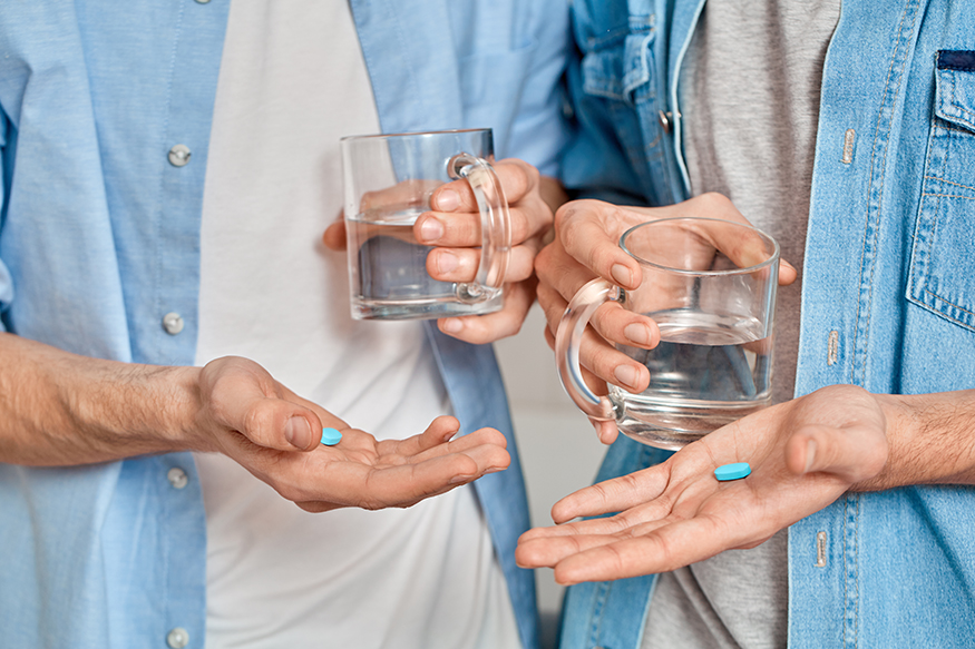 Gay couple holding pre exposure HIV protection pills in hands