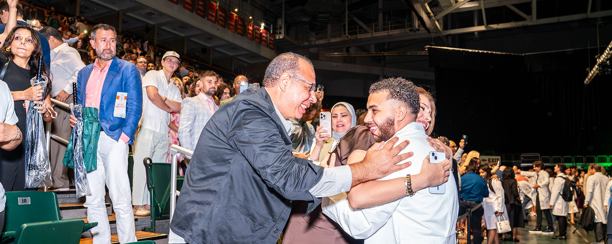 Medical student Abdullah Abdelkawy hugs his parents at the Miller School's white coat ceremony