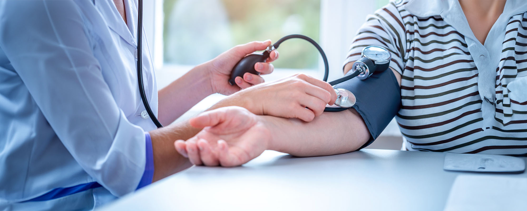 Provider taking a blood pressure reading on a young male patient