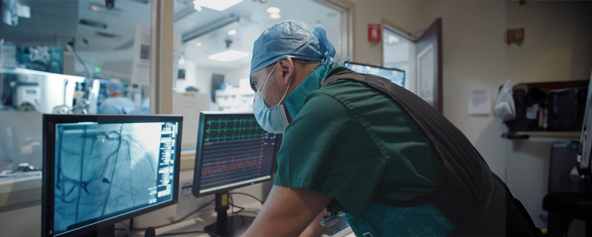 Yiannis Chatzizisis looking at computer monitor outside the operating room