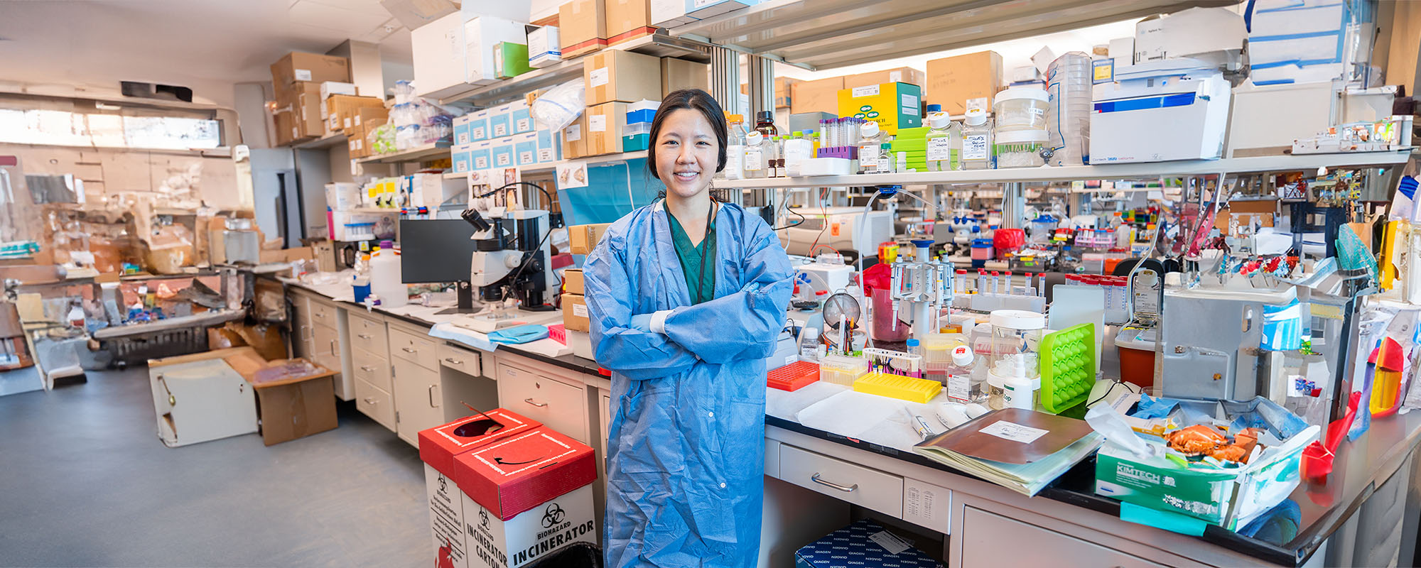 Dr. Diane Jung, standing in the lab with her arms crossed