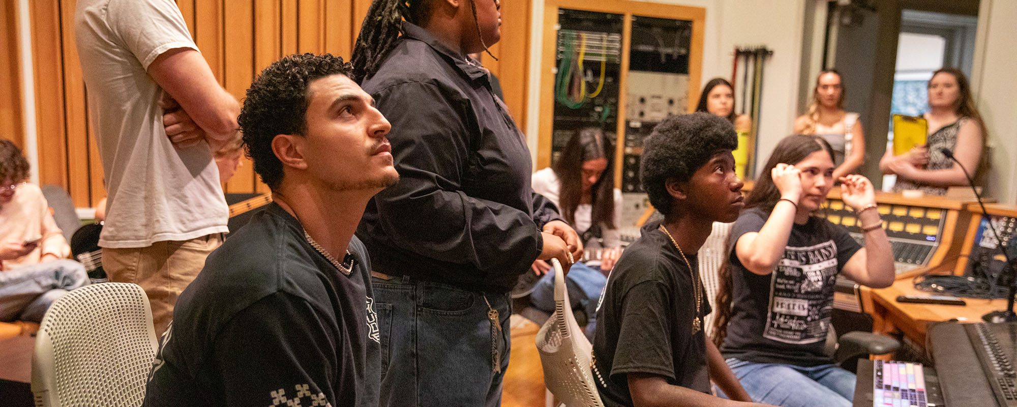 Dolphins star Jaelan Phillips watching MusicReach students he sponsored working in the Weeks Recording Studio at the Frost School